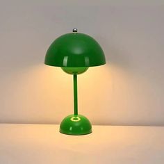 a green lamp sitting on top of a white table