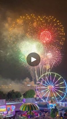 fireworks are lit up in the sky above an amusement park