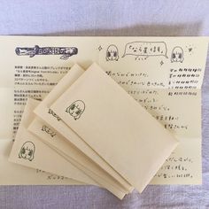 four envelopes with drawings on them sitting on top of a sheet of music paper