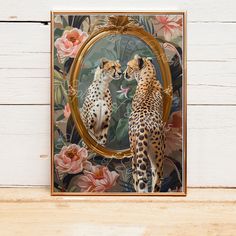 two cheetah standing next to each other in front of a mirror with flowers on it