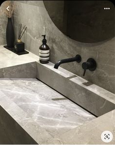 a bathroom sink with soap dispenser and black faucet in it