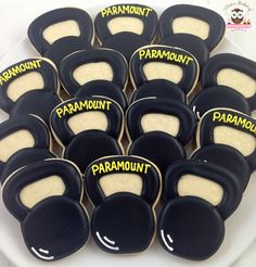 black and yellow decorated cookies on a white plate with words that spell out the word paramount