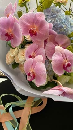 a bouquet of pink orchids and blue hydrangeas