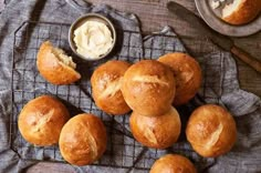 rolls and butter on a towel next to some spoons