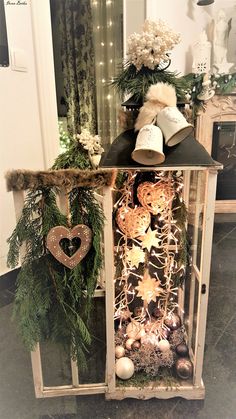 a christmas display case with ornaments and lights on it's sides, including a teddy bear