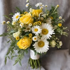 Garden Style Yellow and White Hand-Tied Flower Bouquet Immerse yourself in the enchanting beauty of our garden-style hand-tied bouquet, featuring a delightful mix of yellow and white blooms. This charming bouquet captures the essence of a sunlit garden, bringing a touch of nature’s splendor to any occasion. Bouquet Highlights: Design: Seasonal blooms arranged in a loose, garden-inspired style, this bouquet exudes a natural, freshly-picked look that’s both elegant and relaxed. Presentation: Expertly hand-tied with rustic twine, adding a touch of countryside charm and sophistication. Size: Generously sized at approximately 18 inches in height and 14 inches in diameter, perfect as a statement piece or a heartfelt gift. Fragrance: A light and refreshing scent that evokes the feeling of a strol Wedding Flowers Yellow Roses, Yellow Daisy Wedding Bouquet, Yellow Bouquets Wedding, Green And Yellow Wedding Flowers, Sunflower Prom Bouquet, White And Yellow Bouquet Wedding, Yellow Roses Wedding Bouquet, Hand Tied Bouquet Wedding, Sunflower Wedding Theme Color Schemes