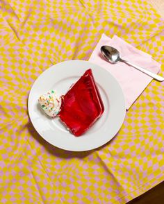 a piece of cake sitting on top of a white plate next to a fork and spoon