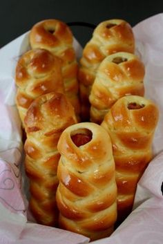 some bread rolls are in a basket on the table