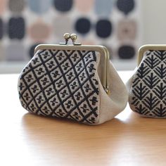 two purses sitting on top of a wooden table