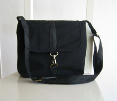 "Beautiful canvas bag. The exterior of this bag is made of solid black upholstery canvas. The fabric is waterproof. The bag closes with a brass clip and d-ring on a black vegan leather strap. There are two inside slip pockets, one is designed to hold a mobile phone. Approximate dimension: width: 10.5\" (26 cm) Height: 9.5\" 25 cm) Depth: 3.5\" (8.5 cm) Strap: Black vegan leather up to 50\" (125 cm) so it can be a shoulder tote or a cross body with ease. '**.¸('**..**')¸.**' ♥*.*BEAUTİFUL*.*♥ ¸.* Canvas Satchel, Black Vegan, Tote Pattern, Computer Bags, Satchel Bag, Black Canvas, Shoulder Tote, D Ring, Bag Straps