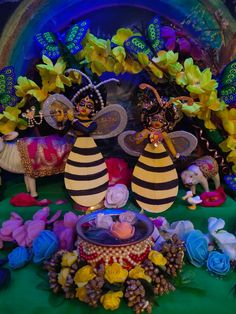 there are two bees on the table with flowers and other things around it, including candles