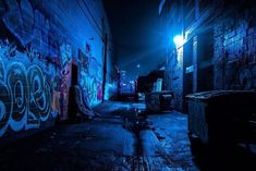 a dark alley with graffiti on the walls