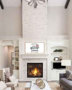 a living room filled with furniture and a fire place under a chandelier in front of a fireplace