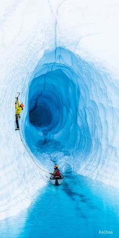 a man in a kayak paddles through an ice cave