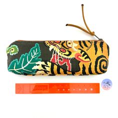 "Atenti Tool Pouch in a fun fabric print called LeTigre with the a Tiger face on the front and tail on the backside. Zipper pull is a Teal Ultra-Suede fabric with a 10\" zipper opening, fully lined in water repellent taffeta. A little vegan notions bag, tool bag, or pencil bag in a woven fabric. This pouch can  be used for a pencil bag, crafting tools, crochet tools, sewing notions anything you need to organize and move. A very beautiful Atenti Knitting Tool Case. Super fun knitter's gift, crafter's gift, student gift or Mother's Day Gift. Measures: 10\"W x 3\" H x 1.5\" base. Made in the USA No discounts allowed on Atenti Bags Listing is for the Tool Pouch only as shown.  Photo 1 front & 2 are the front and back of the Bag. Other photos are of a similar bag. Photo 6 is of a matching LeTig Multicolor Rectangular Pouch With Pen Holders, Handmade Multicolor Pencil Case For Crafting, Multicolor Rectangular Pencil Case For Crafting, Multicolor Zipper Pouch Pencil Case For Crafting, Handmade Multicolor Pouch Pencil Case, Fun Fabric Prints, Knitters Gifts, Notions Bag, Knitting Notions