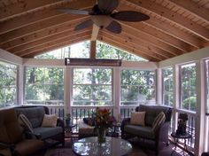 a living room with two couches and a ceiling fan in the middle of it