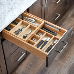 an open drawer with utensils in it