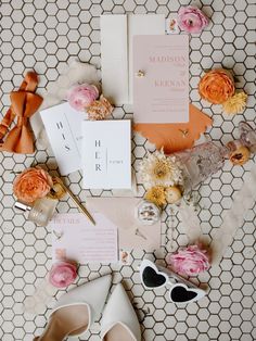 the wedding stationery is laid out with shoes, flowers and other items on it