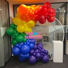 there are many balloons on the wall in this office building that is decorated with rainbow colors