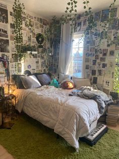 a bed sitting in a bedroom next to a window with lots of pictures on the wall