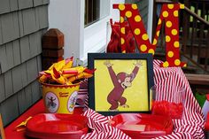 a red table topped with plates and bowls next to a sign that says w is for monkey