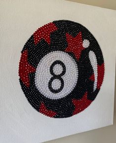 an eight ball beaded onto a canvas with red and white stars on the bottom