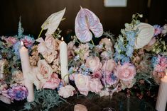 flowers and candles are arranged on the table for an elegant wedding centerpiece with butterflies