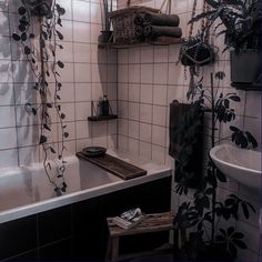 the bathroom is decorated in black and white with lots of greenery on the wall