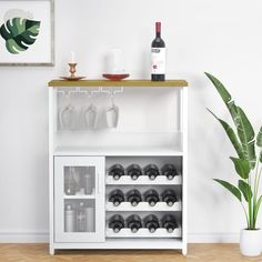 a wine rack with bottles and glasses on it in front of a white painted wall