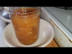 a jar filled with liquid sitting on top of a white plate