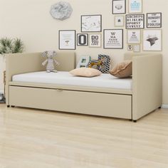 a day bed with storage underneath it and pictures on the wall