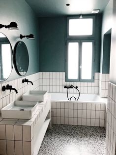 a bathroom with two sinks, mirrors and a bathtub in the middle of it