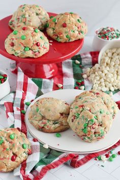 cookies with sprinkles and white chocolate chips on a red plate next to other holiday treats