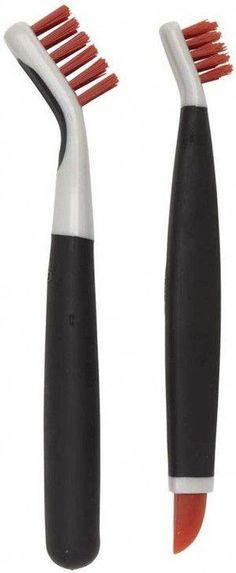 two black and white toothbrushes with red bristles