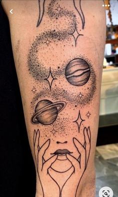 a person with tattoos on their legs holding hands up to the sun and planets above them