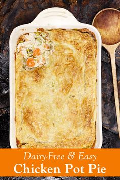 a casserole dish with vegetables in it and a wooden spoon on the side