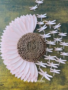 paper flowers and dragonflies on a wooden surface