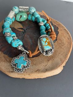 Colorful turquoise heisi, nugget and round beads of Thai silver, embossed ceramic and howlite will surround a larger wrist with two bands of art.  A sterling and Turquoise Artisan button and leather loop closure can be adjusted for comfort. Hand Wrapped Artisan Turquoise Bracelets, Artisan Turquoise Bracelets With Natural Stones, Artisan Hand Wrapped Turquoise Bracelets, Artisan Hand Wrapped Turquoise Bracelet, Hand Wrapped Artisan Turquoise Bracelet, Artisan Wrap Bracelet With Round Beads, Artisan Turquoise Beaded Bracelet, Rustic Handmade Turquoise Beaded Bracelets, Artisan Turquoise Beaded Bracelets