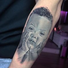 a black and grey tattoo of a child holding his hand up to his face,