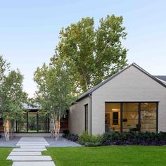 a modern home with stone walkway leading to the front door