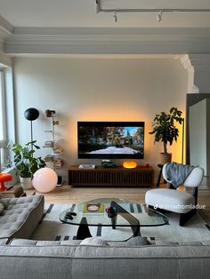 a living room filled with furniture and a large flat screen tv mounted on the wall