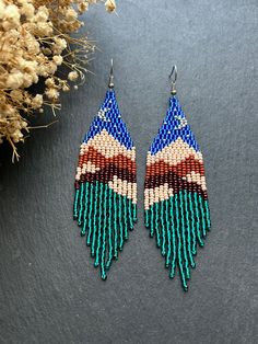 a pair of beaded earrings sitting on top of a table