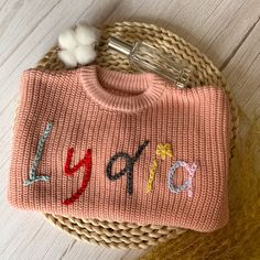 Welcome to our store! Step into the world of personalized baby sweaters! Each sweater is meticulously hand embroidered with your child's name in cursive on the chest or back. We offer your choice of chunky or extra chunky yarns to make each sweater unique. Each one-of-a-kind heirloom is customized and hand-embroidered on a high-quality, super soft, 100% cotton, oversized sweater (truly handmade by you  Every stitch is a labor of love. Our personalized sweaters make extraordinary gifts, perfect for baby welcome parties, delightful holiday surprises, joyous birthday celebrations, heartwarming group photos, precious milestone moments, or a unique way to say "Congratulations!" ! Impress the new mom or mom-to-be. Customized Details: Please be sure to provide all necessary personalization detail Personalized Cotton Sweater For Winter, Personalized Pink Crew Neck Sweater, Pink Winter Sweater With Embroidered Logo, Personalized Pink Long Sleeve Sweater, Personalized Pink Sweater For Winter, Pink Cotton Sweater With Custom Embroidery, Handmade Cotton Crew Neck Sweater, Cute Pink Sweater With Custom Embroidery, Name In Cursive