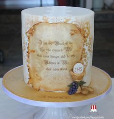 a cake decorated with an old scroll and some grapes on the side, sitting on a plate