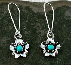 "Sweet and pretty little turquoise flower dangle earrings.  They are unique and versatile.  Dress them up or down.  The perfect everyday earrings. The flowers measure 1/2\" long 1/2\" wide.  They hang from kidney style ear wires that latch and lock.  Overall drop length is 1 1/2\". Made from plated silver. I have this same earring style also available with a red stone accent.  Here is a direct link https://www.etsy.com/listing/1387351493/ Thanks for stopping by!  Please take a moment and visit t Turquoise Nickel Free Flower Earrings, Turquoise Dangle Earrings With Flower Charm, Nickel Free Turquoise Flower Earrings, Turquoise Flower-shaped Earrings With Flower Charm, Turquoise Earrings With Flower Charm, Turquoise Flower Earrings Gift, Turquoise Earrings With Flower Charm As Gift, Adjustable Turquoise Flower Earrings Gift, Turquoise Dangle Flower Earrings With Ear Wire