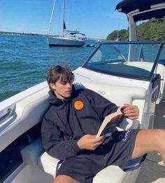 a man sitting in the back of a boat reading a book