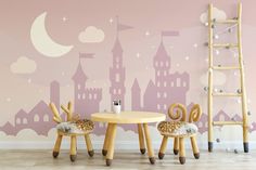 two children's chairs and table in front of a wall with castle silhouettes