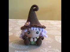 a small crocheted doll sitting on top of a table