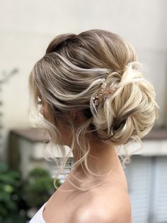 a woman with blonde hair in a low bun