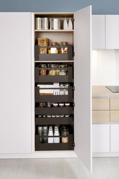 an open pantry door in a white kitchen